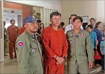  ?? NIEM CHHENG ?? Election official and former Adhoc staffer Ny Chakrya is escorted out of the Phnom Penh Municipal Court yesterday after his hearing.