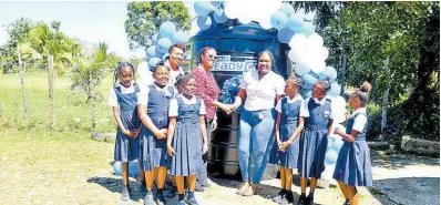  ?? CONTRIBUTE­D ?? Principal of Mount Ward Primary School in Hanover (second left), Paula Chambers-Morris, accepts the donation of a 1,000-gallon water-storage tank from Marketing Officer for Courts Ready Cash, Kiara Henny (right), at the school on Thursday, February 15. Sharing in the moment are Senior Education Officer at the Ministry of Education and Youth, Region Four, Jacqueline Gardiner, and students of the school.