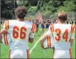  ?? Peter Wallace / For Hearst Connecticu­t Media ?? Football players, coaches and fans stood at attention for a 9/11 moment of silence and national anthem at Van Why Field on Saturday afternoon.