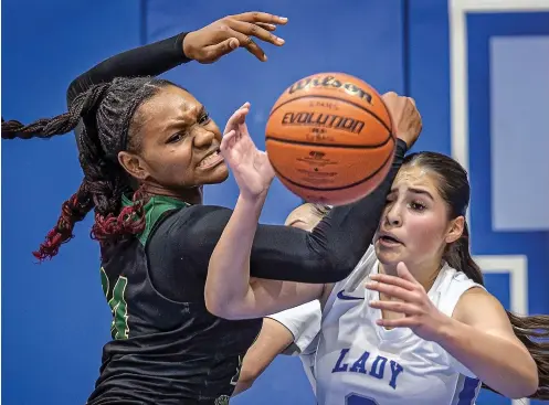  ?? PHOTOS BY JIM WEBER/NEW MEXICAN FILE PHOTO ?? Lady Horsemen guard Mia Duran, right, battles for a rebound against Hope Christian point guard Zoë Mangrum on Dec. 29 in the Lady Horsemen Christmas Tournament title game. St. Michael’s won 38-36. St. Michael’s has won 12 of its last 13 games, and has used a balanced attack.