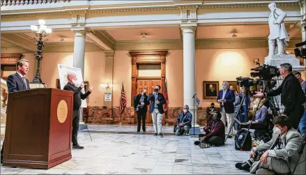  ?? JENNI GIRTMAN FOR THE AJC ?? Gov. Brian Kemp, announcing the expanded state vaccine sites at the Capitol, says Georgia’s lagging pace in administer­ing first doses was because of “intense demand” from health care workers and Georgians over 65 who are in need of second shots.