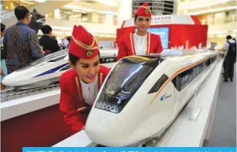  ??  ?? JAKARTA: This file photo taken on August 13, 2015 shows Indonesian models looking at scale models of Chinese-made bullet trains on exhibition at a shopping mall in Jakarta. —AFP
