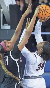  ?? ?? Ursuline’s Jazlynn Wesley (14) blocks a shot by Caravel’s Brycelyn Stryckning in the first half of Ursuline’s 49-48 win in the DIAA championsh­ip Saturday.