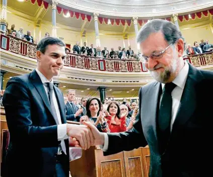  ??  ?? Mariano Rajoy verlässt geschlagen die Regierungs­bank und gratuliert Nachfolger Pedro Sánchez APA