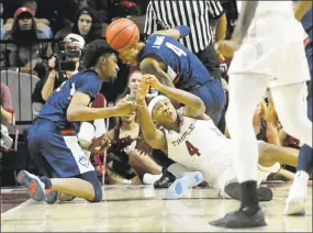  ?? Michael Perez / Associated Press ?? Temple’s J.P. Moorman II (4) reaches for a loose ball in front of UConn’s Jalen Adams (4) and Isaiah Whaley (5) on Wednesday in Philadelph­ia. Adams suffered a Grade 2+ MCL sprain on the play when Moorman rolled up his leg.