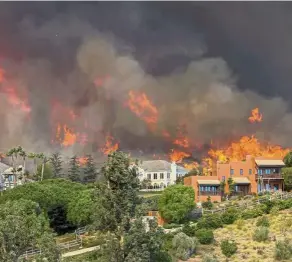  ??  ?? California burning: Rubble littering a lot on Skyway after a wildfire burned through Paradise as the Woolsey Fire (above) approaches homes in Malibu. — AP/AFP