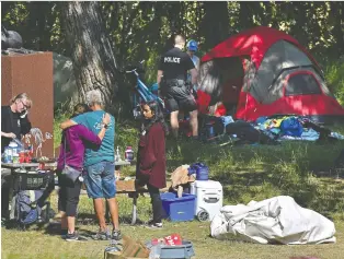  ?? ED KAISER ?? Residents of a homeless camp at Queen Elizabeth Park were given two hours to pack their belongings Friday. Police were on hand to help as residents were taken by bus to a shelter or other alternate housing.