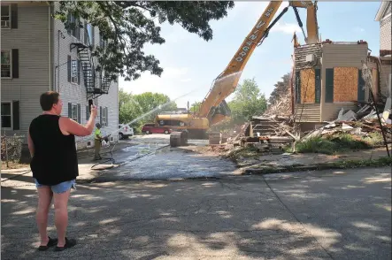  ?? Photos by Ernest A. Brown ?? Above: Neighbor Melissa Begnoche, left, who lives next door to 46-48 Burnside, was on scene to take pictures of the demolition. She became emotional and began to weep when the final front section of the building was brought down. She said she had many memories of her kids, now grown adults, playing in the front yard of the house. Below right: Woonsocket Mayor Lisa Baldelli-Hunt, right and Constructi­on Supervisor Tom Koback stopped by Friday afternoon just as the demolition was completed. The two buildings were problem properties for the city, with constant complaints of drug dealing, landlord problems and other issues.