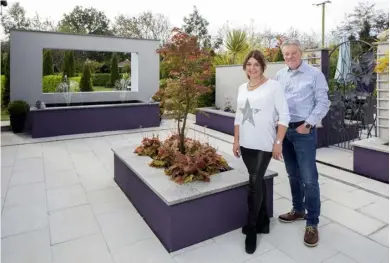  ??  ?? Above: Simone and Joe in the courtyard between their home and the gallery. It was Simone’s idea to put the frame-like structure above the fountain, the better to focus the eye on the garden beyond. “I thought it would be nice to make the wall behind the fountain more like a frame to emphasise the view,” says Simone
Right top: A view of the house and the gallery from the end of the two-and-a-halfacre garden