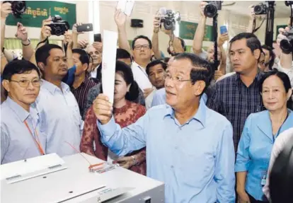  ?? AP ?? El primer ministro de Camboya, Hun Sen, se aprestaba votar ayer en un recinto electoral en Nom Pen.