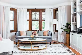  ?? CAROLINA MARIANA RODRIGUEZ/PHOTOS FOR THE CHICAGO TRIBUNE ?? In the living room, a Moroccan-inspired wood rug lends a Bohemian vibe to the velvet-covered sofa, while a high-end marble-and-brass cocktail table adds to the eclectic array of pieces.