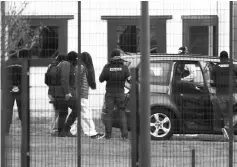  ??  ?? A handcuffed person escorted by security forces leaves the Penitentia­ry center of Alencon, in Conde-sur-Sarthe, northweste­rn France where a detainee seriously wounded two guards earlier in a knife attack.