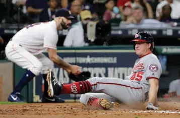  ?? Associated Press ?? n Washington Nationals' Andrew Stevenson (45) scores on a sacrifice fly by Wilmer Difo during the third inning of a baseball game against the Houston Astros on Wednesday in Houston.