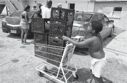  ?? Matt Sedensky / Associated Press ?? Christophe­r Williams, 5, pushes a shopping cart outside his family’s destroyed apartment in Luling, La., last week. The boy and his two brothers are among an estimated 250,000 children across Louisiana with no school to go to after Hurricane Ida.