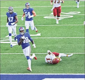  ?? Ricky Carioti / The Washington Post ?? New York Giants linebacker Tae Crowder carries the ball in for a touchdown after scooping up a fumble during the fourth quarter at MetLife Stadium on Sunday against Washington.