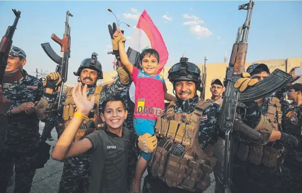  ?? Picture: AFP ?? JUBILANT: Iraqi federal police and children celebrate the end of military operations against Islamic State fighters in the Old City of Mosul.