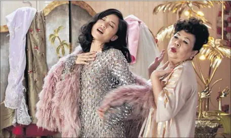  ?? Warner Bros. Pictures ?? CONSTANCE WU, left, and Koh Chieng Mun share a rollicking scene in the contempora­ry romantic comedy “Crazy Rich Asians.”