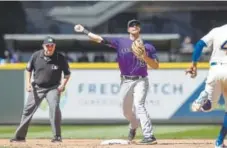  ?? Stephen Brashear, Getty Images ?? Rockies second baseman DJ LeMahieu turns a double play during the eighth inning Sunday at Safeco Field.