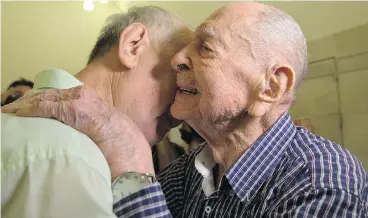  ?? SEBASTIAN SCHEINER / THE ASSOCIATED PRESS ?? Israeli Holocaust survivor Eliahu Pietruszka, right, embraces Alexandre Pietruszka as they meet for the first time in Kfar Saba, Israel. Pietruszka, who fled Poland at the beginning of the Second World War and thought his entire family had perished,...