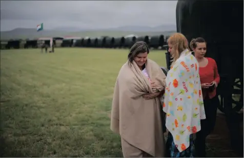  ??  ?? An Afrikaner woman, left, holding her baby as she stands in the middle of the ox wagon monument during a Boer War memorial held at the site of the Battle of Blood River near Dundee on December 16, 2014.