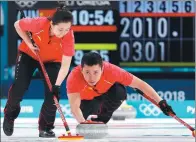  ?? CATHAL MCNAUGHTON / REUTERS ?? Wang Rui of China sweeps as Ba Dexin delivers the stone during China’s 9-7 loss to Norway in the Olympic curling mixed doubles tiebreaker on Sunday. The loss denied China a semifinal spot.