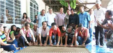  ??  ?? (Squatting, from third right) Tuai Rumah Mary Ingkok, Sng, Wong and others roll the mat to mark the closing of Gawai at Rumah Mary.