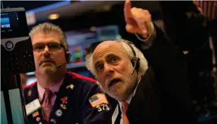  ?? — AFP ?? Traders work on the floor at the closing bell of the Dow Industrial Average at the New York Stock Exchange in New York.