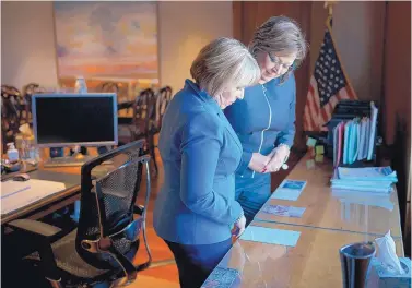  ?? CRAIG FRITZ/ASSOCIATED PRESS ?? Gov.-elect Michelle Lujan Grisham, left, and Gov. Susana Martinez look at memorabili­a in the Governor’s Office during a meeting at the state Capitol in Santa Fe to discuss Lujan Grisham’s transition into the office.