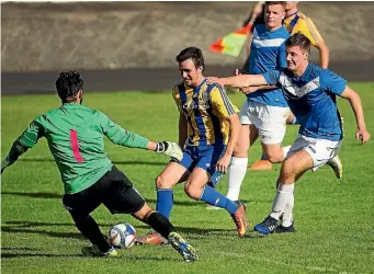  ?? PHOTO: DAVID UNWIN/FAIRFAX NZ ?? Havelock North Wanderers striker Harrison Gregory, centre, looks to beat Massey goalkeeper Antonio Degregorio, left, with defender Mitchell Evans trying to get in on the act during their game on Saturday.