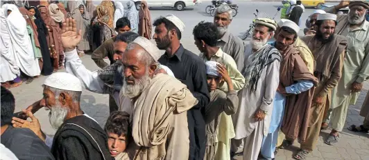  ??  ?? Cash call: People queue at an ATM in Peshawar, Pakistan, where cards loaded with funds from UK taxpayers are being used