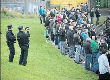  ?? COLIN MCPHERSON / GETTY ?? La policia filma els seguidors locals en un partit entre el Glentoran i el Cliftonvil­le