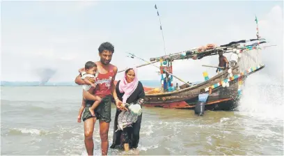  ?? — Gambar Reuters ?? SENGSARA: Asap tebal berkepul dari bahagian sempadan Myanmar ketika pelarian Rohingya turun dari bot setelah merentasi sempadan melalui Teluk Bengal di Shah Porir Dwip, Bangladesh kelmarin.