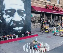  ?? JOSHUA RASHAAD MCFADDEN/THE NEW YORK TIMES ?? A mural depicting George Floyd and makeshift memorials are seen in March outside Cup Foods in Minneapoli­s.