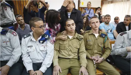  ??  ?? THE FATHER of convicted Sgt. Elor Azaria (center) prays behind him in a military court during a remand hearing for his case last March.