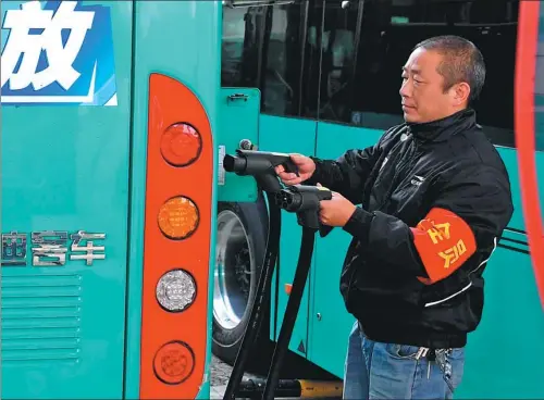  ?? XINHUA ?? An employee charges a bus, one of 721 electric vehicles that help to improve air quality in Bengbu city, Anhui province.