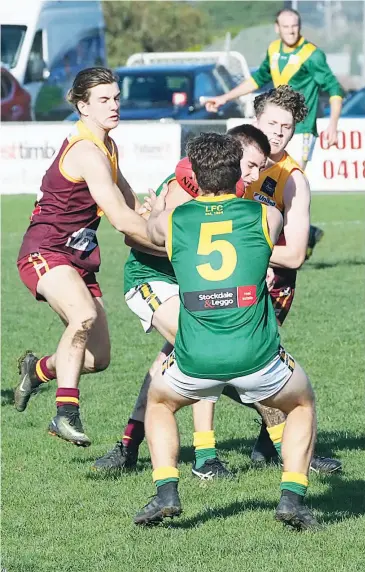  ??  ?? Jake Simpson (left) and Jye Mitchell (at rear), two of Drouin’s graduates from last year’s thirds, wrap up a Leongatha opponent and force the ball to spill, typifying the pressure the Hawks exerted in a spirited effort against the reigning premier.