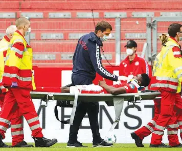  ?? PHOTO: AFP ?? Taiwo Awoniyi being stretchere­d off after suffering a serious head injury in the Bundesliga relegation battle against Augsburg… yesterday.