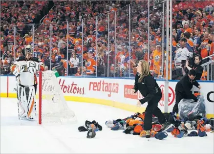  ?? Photograph­s by Codie McLachlan Getty Images ?? A HAT TRICK by Edmonton’s Leon Draisaitl led to a delay in the second period, when workers cleared the ice of caps thrown by celebratin­g fans while Ducks goalie Jonathan Bernier stewed in front of his net. Draisaitl had two assists to go with his three...