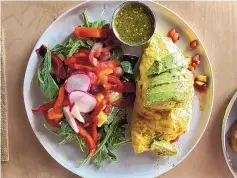  ?? ?? The omelet featured calabacita­s, tomatoes, green chile and goat cheese with avocado on top and a side of arugula salad with raw spinach, roasted beets, sliced red peppers, radishes and slightly sweet walnut vinaigrett­e.