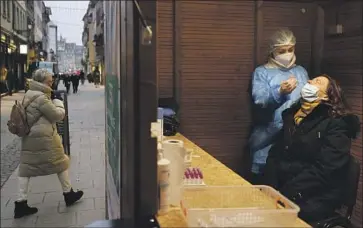  ?? Jean-Francois Badias Associated Press ?? A WOMAN takes a coronaviru­s test in Strasbourg, France, last week. France, Britain and Germany are among the countries in Europe that have reported finding Omicron variant cases within their borders.