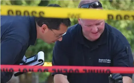  ?? CHRIS CHRISTO PHOTOS / HERALD STAFF ?? ‘BRAZEN ATTACK’: Boston police investigat­ors, above and below, gather evidence on Warren Street in Roxbury where a man was shot Friday afternoon.