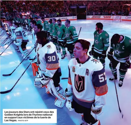  ?? PHOTO AFP ?? Les joueurs des Stars ont rejoint ceux des Golden Knights lors de l’hymne national en support aux victimes de la tuerie de Las Vegas.