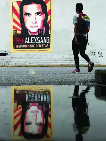  ?? EFE ?? Un hombre pasa en Caracas junto a un cartel en apoyo del empresario colombiano Alex Saab