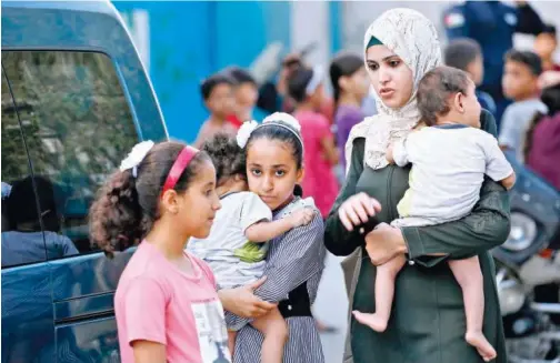  ?? Agence France-presse ?? ↑
A Palestinia­n mother picks up her children from a school run by the United Nations Relief and Works Agency in Gaza City on Thursday.