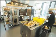  ?? Associated Press ?? Joseph Robello, lead cook at Mary’s Place, a family homeless shelter located inside an Amazon corporate building on the tech giant’s Seattle campus, prepares food June 17.