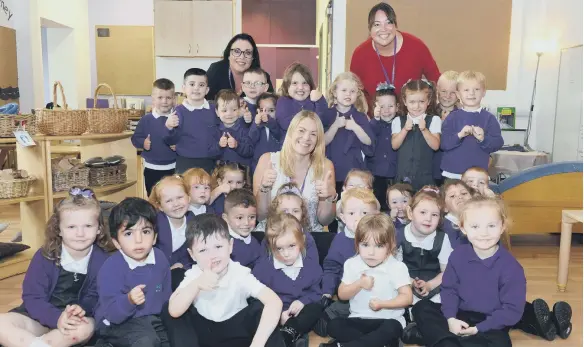  ??  ?? Early Years lead Catherine White, centre, with pupils and staff at Marlboroug­h Primary School, nominated in the Early Years in School category at the Nursery World awards.