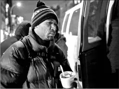  ??  ?? A homeless man receives a hot meal during winter storm Grayson in Manhattan, New York City, US.