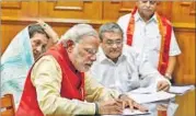  ??  ?? Narendra Modi signs poll papers in Vadodara on Wednesday. REUTERS