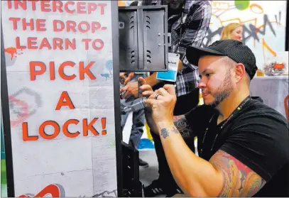  ?? K.M. Cannon ?? Las Vegas Review-journal @Kmcannonph­oto Joel Thomassino of Nashville, Tenn., tries to pick a lock to win a prize at the Coalfire Labs booth Wednesday during the Black Hat annual cybersecur­ity conference at Mandalay Bay.