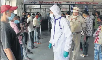  ??  ?? A health worker checks Covid report of the passenger at a railway station in Jalandhar on Monday.